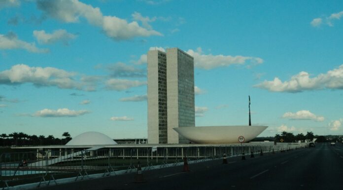 Prédio do Congresso Nacional, em Brasília, sob céu azul com nuvens